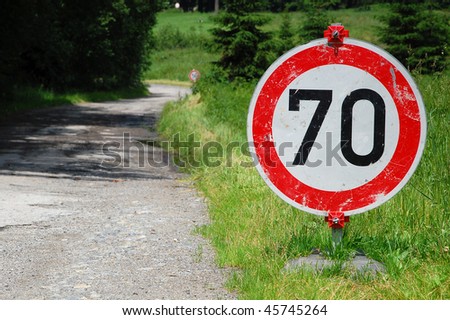Temporary road sign for speed limit. Apparantely useless on such poor road. One more is in background.