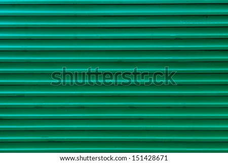 Green, steel, shiny rolling shutter door texture with horizontal lines.