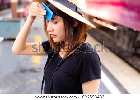 Beautiful woman feels so hot and tired in the summer season. Attractive beautiful girl uses facial tissue for sweating on her face. Charming beautiful woman is going to faint from the hot weather