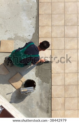 Floor tiles installation. Man installs ceramic tile