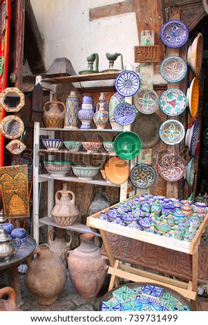 Traditional moroccan souvenirs - plates, tagines, mirrors, and pots made of clay, souk in Fes, Morocco, Africa