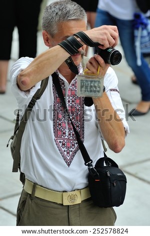 KIEV, UKRAINE - AUGUST 24: A journalist in national costume making photos at All Ukrainian Vyshyvanka Parade at Independence Day on August 24, 2013 in Kiev, Ukraine
