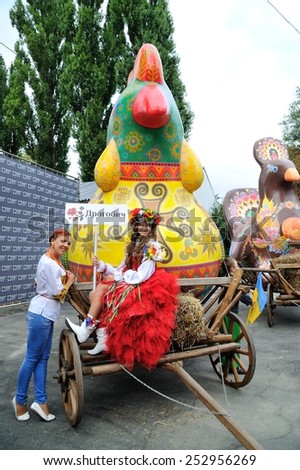 KIEV, UKRAINE - AUGUST 24: Girls making photos with a wonderwork-bird - a symbol and work of art each of the ukrainian regions specially made for All Ukrainian Vyshyvanka Parade at Independence Day
