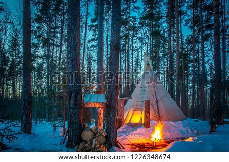 TIPI. Winter. Tipi stands in the winter forest. Bonfire in the forest. Eco-friendly tourism. National dwellings. National Indian dwellings.