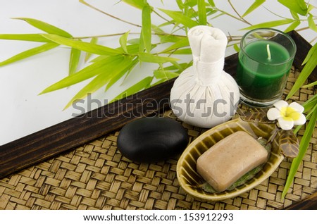 Spa massage,candle, zen stone, Herbal massage balls,Bamboo leaves and organic soap bars  on bamboo tray.