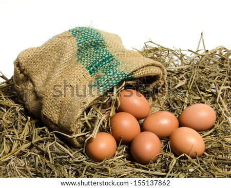 Aga chicken eggs are poured out of a sack of rice straw placed on the white background.