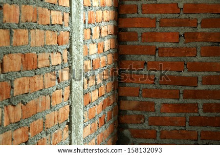 Orange brick wall with cement is formed with reinforced concrete columns to increase their strength.