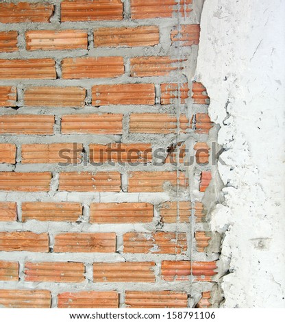 Cement plastered brick wall, unfinished to see the texture of the brick.