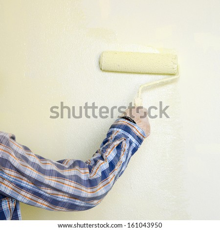Painters are painting walls with a roller for painting.