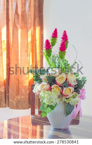 Beautiful Fake Flowers in White pot on wood table, cool tone