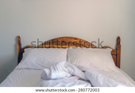 Empty bed with white sheet