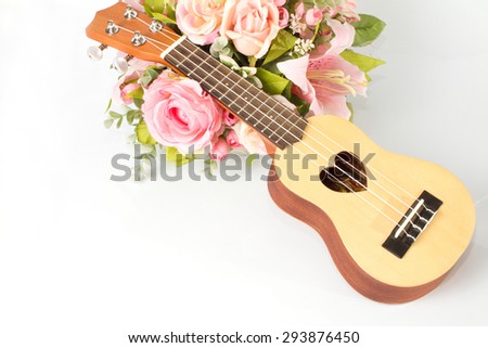 Ukulele and beautiful flower on white background