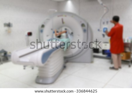 Blurred background : Young male nurse preparing patient for CT scan test in examination room