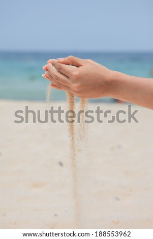 hand pours sand