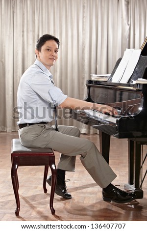 A young man playing piano on the stage