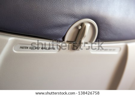 inside airplane seat, focusing with the warning label of \