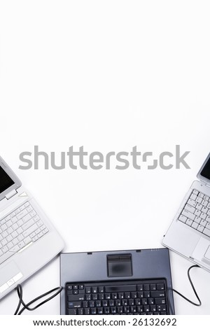 Three laptop arranged to frame white background with black cable connecting them.