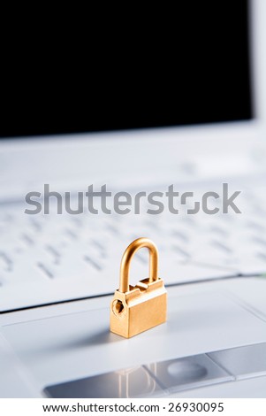 Golden lock on the laptop, focus mainly on the front side of the lock.