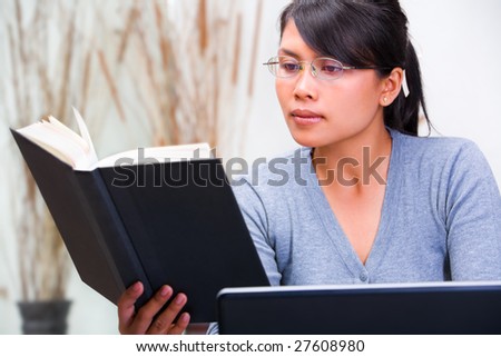 Young Asian scholar woman reading a book