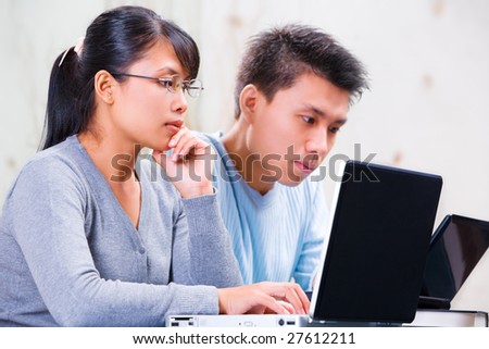 Both young Asian scholar using laptop.