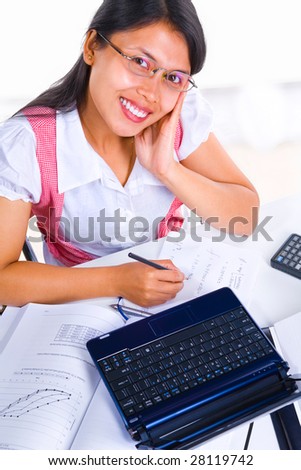 An Asian female scholar looking at the camera while studying.