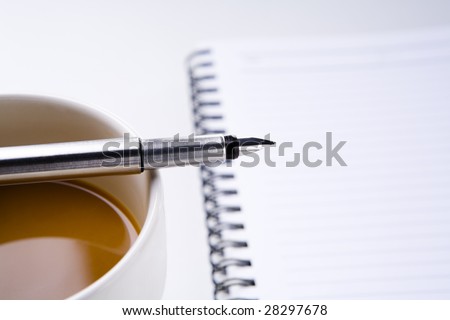 Concept for break time in study time, using pen place on coffee cup and book blurred in background