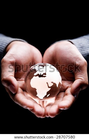 Hands holding a glass globe showing Africa, Europe and part of Middle East