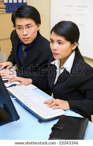 A businessman watching at the computer screen which her partner works on. Focus on the man.