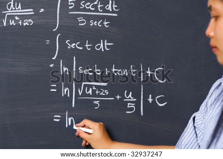 Female student working on mathematics problem on blackboard