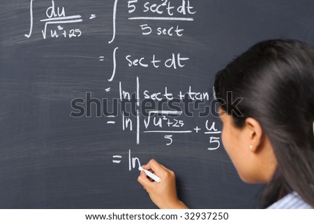 Female student working on mathematics problem on blackboard