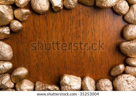 Wood framed by golden nuggets can be used for background. Focus on the wooden texture