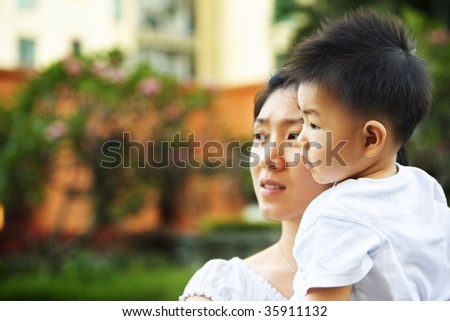 Mother and son waiting father to come home in apartment\'s garden area in the afternoon