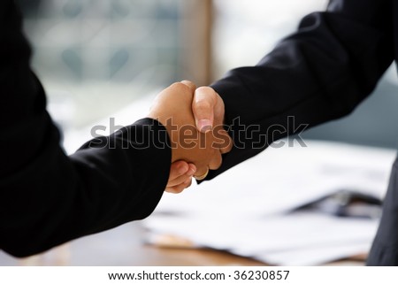 close up image of handshake between two businesswomen. Different skin tones