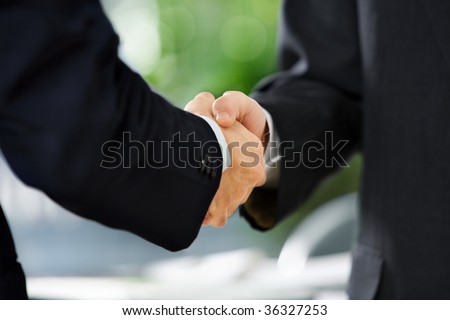 close up image of handshake between two businessmen. East Asian skin tone
