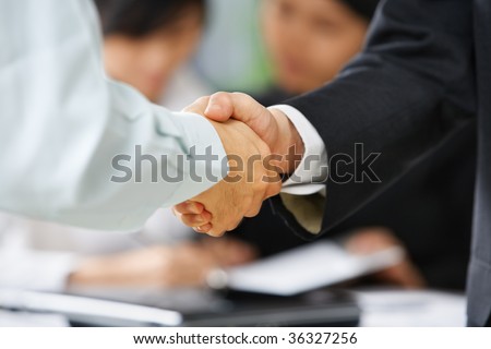 Handshake between employee and boss to illustrate he is being accepted in the team