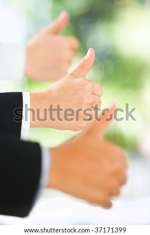 People raise thumbs up in line with green environment background