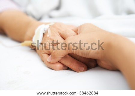 Daughter holding her mother hand, that injected with IV  in hospital