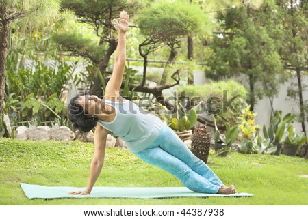 Senior Asian woman doing stretching for yoga in garden