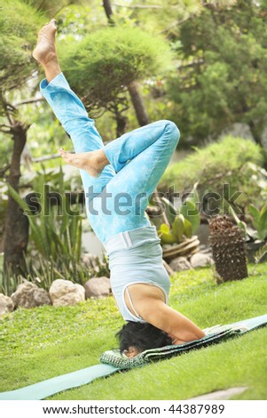 Senior old Asian woman doing yoga in park alone