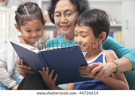 Grandma and grandchildren reading book together at home