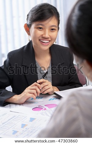 Chinese businesswoman talking to her client in the office