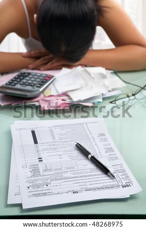 Tax from and frustrated woman with pile of bills