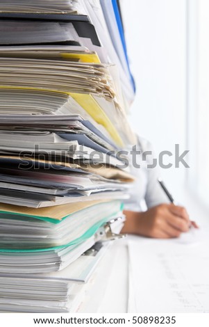 Workload concept with high pile of paperwork. Selective focus