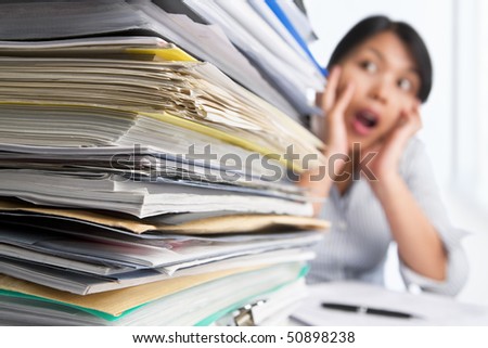 Heavy workload concept with surprised woman on background. Selective focus