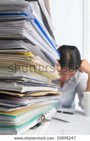 Lots of workload with stress people on background. PS: small depth of field and selective focus on papers