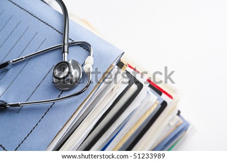 Medical record concept with stethoscope over pile of document. Selective focus on the front side of the stethoscope