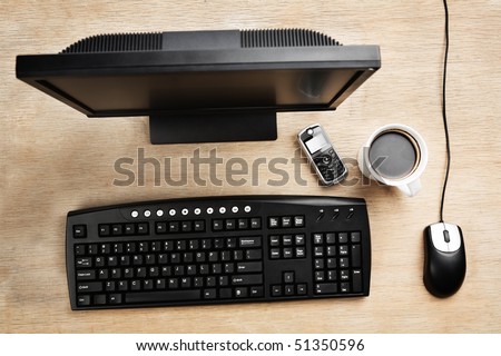 Working desk filled with Computer, cell phone and mug of coffee