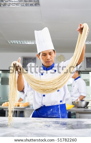 Chef making noodle in the kitchen of cooking school. ***PS : selective focus on the noodle ***