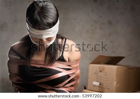 stock photo A young woman tiedup blind folded and muted in old