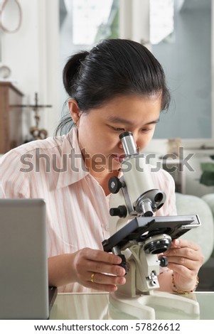 Chinese woman working with microscope for research